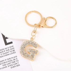 Detailed view of crystal-encrusted letter G keychain with golden lobster clasp and ring