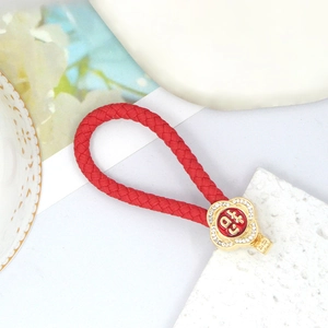Roter geflochtener Schlüsselanhänger mit goldenem Strass-Blumenanhänger und Glückssymbol