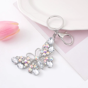 Détail d'un porte-clés papillon orné de strass avec un fermoir mousqueton argenté et anneau