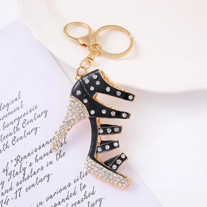 Dettaglio portachiavi a scarpa col tacco dorata con smalto nero e strass scintillanti