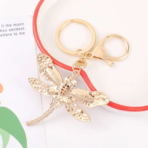 Detail of dragonfly keychain with hollow wings, gold metal finish and lobster clasp