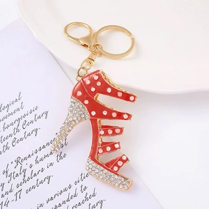 Dettaglio di un portachiavi a scarpa col tacco rosso con strass bianchi e finitura oro
