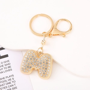 Macro view of gold crystal letter M keychain with sparkling rhinestones and lobster clasp