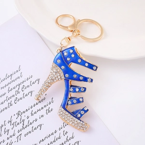 Portachiavi elegante a forma di scarpa con tacco dorato, smalto blu e strass brillanti