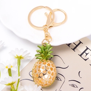 Pineapple keychain charm featuring golden metal heart cutouts and green enamel details
