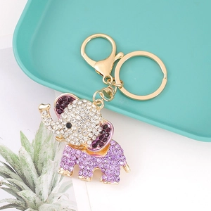 Detailed macro of gold elephant keychain with sparkling purple and white rhinestones