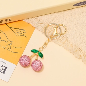 Portachiavi a ciliegia con strass rosa, foglie verdi e moschettone in metallo dorato