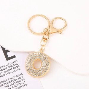 Close-up of golden rhinestone-encrusted round keyring with lobster clasp and metal chain