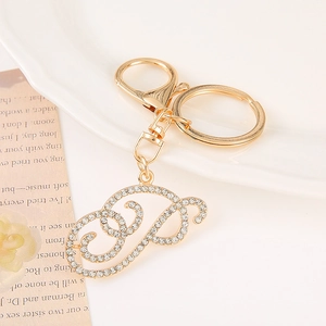 Macro view of gold-plated letter P keychain featuring sparkling rhinestone inlays