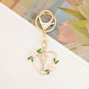 Close-up of heart-shaped gold keychain with letter Y and sparkling rhinestones