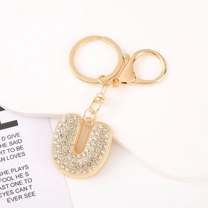 Detailed macro view of crystal-encrusted letter U keychain with gold-tone hardware and clasp