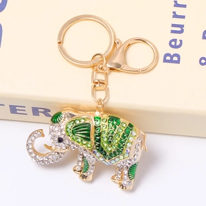 Detail shot of golden elephant keychain with sparkling rhinestones and green enamel accents