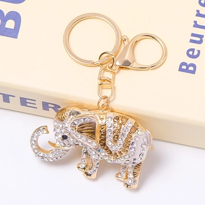 Detail of a crown elephant keychain with sparkling rhinestones on an antique book