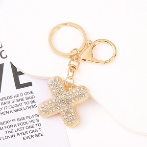 Macro view of gold letter X keychain pendant with sparkling rhinestones and lobster clasp
