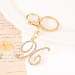 Close-up of sparkling rhinestone-encrusted golden letter G keychain with lobster clasp
