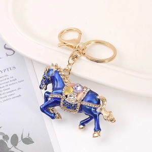 Blue horse keychain with multicolored crystals and gold metal finish on white background
