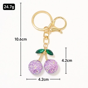 Portachiavi a ciliegia dorato con strass viola e charm foglia verde scuro per borse