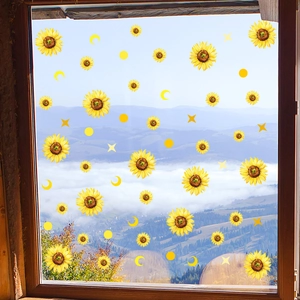 Detailansicht der gelben Sonnenblumen- und Mond-Fensteraufkleber auf Glas vor Gebirgspanorama