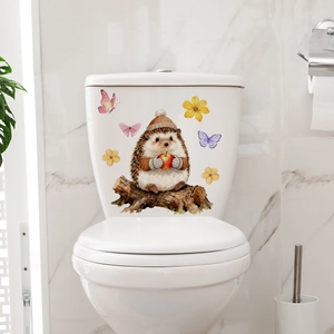 Detailed close-up of a cute hedgehog and apple sticker on a white ceramic toilet tank