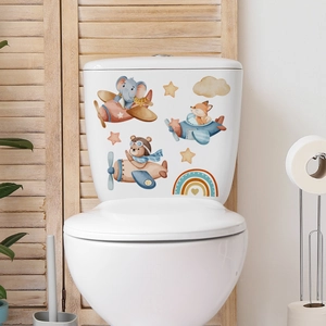 Detailed view of cartoon animal toilet stickers featuring an elephant flying a plane on white tank