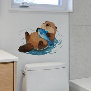 Detailed wall decal of a cute brown otter with a blue fish on a clean bathroom wall