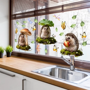 Detail of cute hedgehog and butterfly window stickers on a bright kitchen window glass