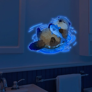 Luminous sea otter wall sticker showing blue glow effect in dark bathroom setting