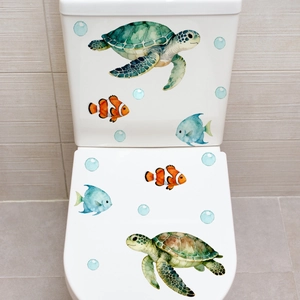 Detailed realistic sea turtle and tropical fish stickers applied to a white ceramic toilet