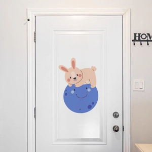 Glow-in-the-dark cartoon rabbit and moon wall sticker applied on a white wooden door