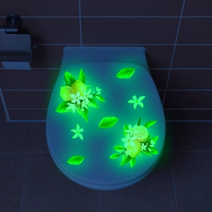 Glow-in-the-dark lemon and floral toilet stickers illuminating in dark bathroom