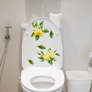 Close-up of fresh lemon and white flower decals applied on a white toilet lid