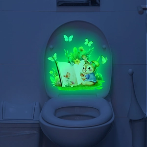 Luminous toilet sticker showing a glowing cartoon rabbit and butterfly in the dark