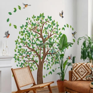 Detail of cartoon tree wall decal with green leaves and birds in a cozy living room scene