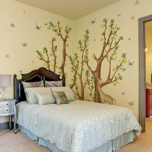 Detailed view of forest wall decals with giraffe and tree on a bedroom corner wall
