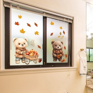 Detail of cute bear window clings with pumpkin cart and maple leaf autumn decor