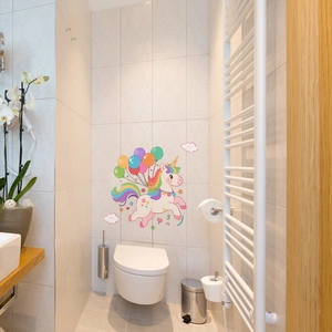 Luminous unicorn wall sticker with rainbow balloons applied on clean bathroom tiles