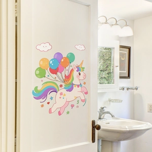 Detailed view of luminous unicorn and rainbow wall decals applied to a white wooden door