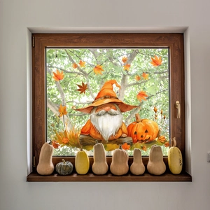 Close-up of autumn gnome with pumpkin and maple leaf decals on a glass window pane