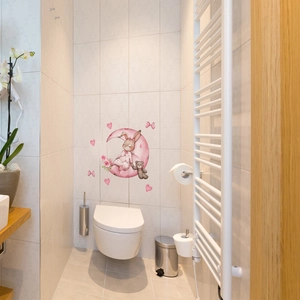 Luminous bunny sitting on a pink moon wall sticker on a white bathroom tile wall