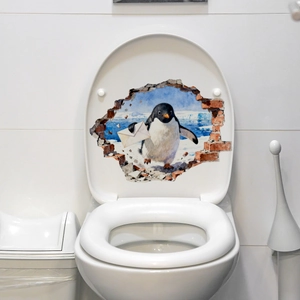 Vue détaillée d'un autocollant 3D de pingouin brisant le mur posé sur un couvercle de WC