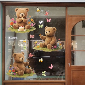 Detail of cartoon bear and butterfly window clings applied to a glass door surface