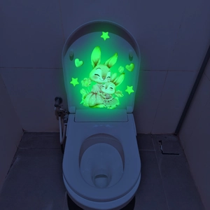 Luminous wall sticker showing glowing cute bunnies and stars in a dark bathroom setting