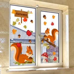 Detail of autumn window clings with squirrels, mushrooms and maple leaves on glass