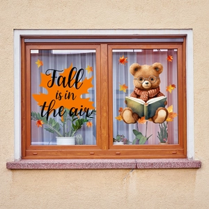 Detail of fall window stickers featuring an orange maple leaf and a bear reading a book