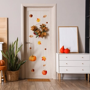Detail showing autumn maple leaves and pumpkin wall stickers on a light wooden door