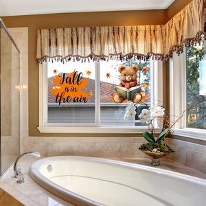 Detail of fall window stickers featuring autumn bear and orange maple leaf decals on glass