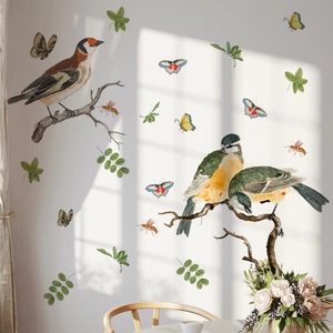 Detail of realistic birds and butterfly wall stickers on a white wall in natural light