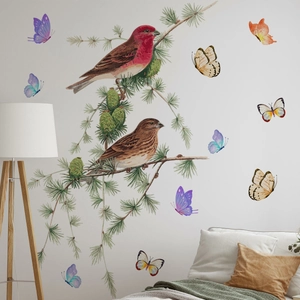 Macro detail of bird and butterfly wall stickers with pine branches on bedroom wall
