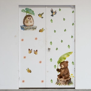 Détail de stickers muraux animaux de la forêt avec ours et hérisson sur une porte blanche