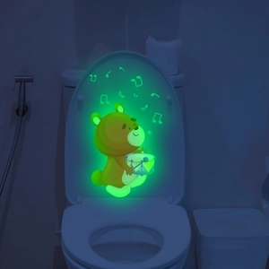 Glow-in-the-dark bear sticker playing drums with luminous musical notes on a toilet lid